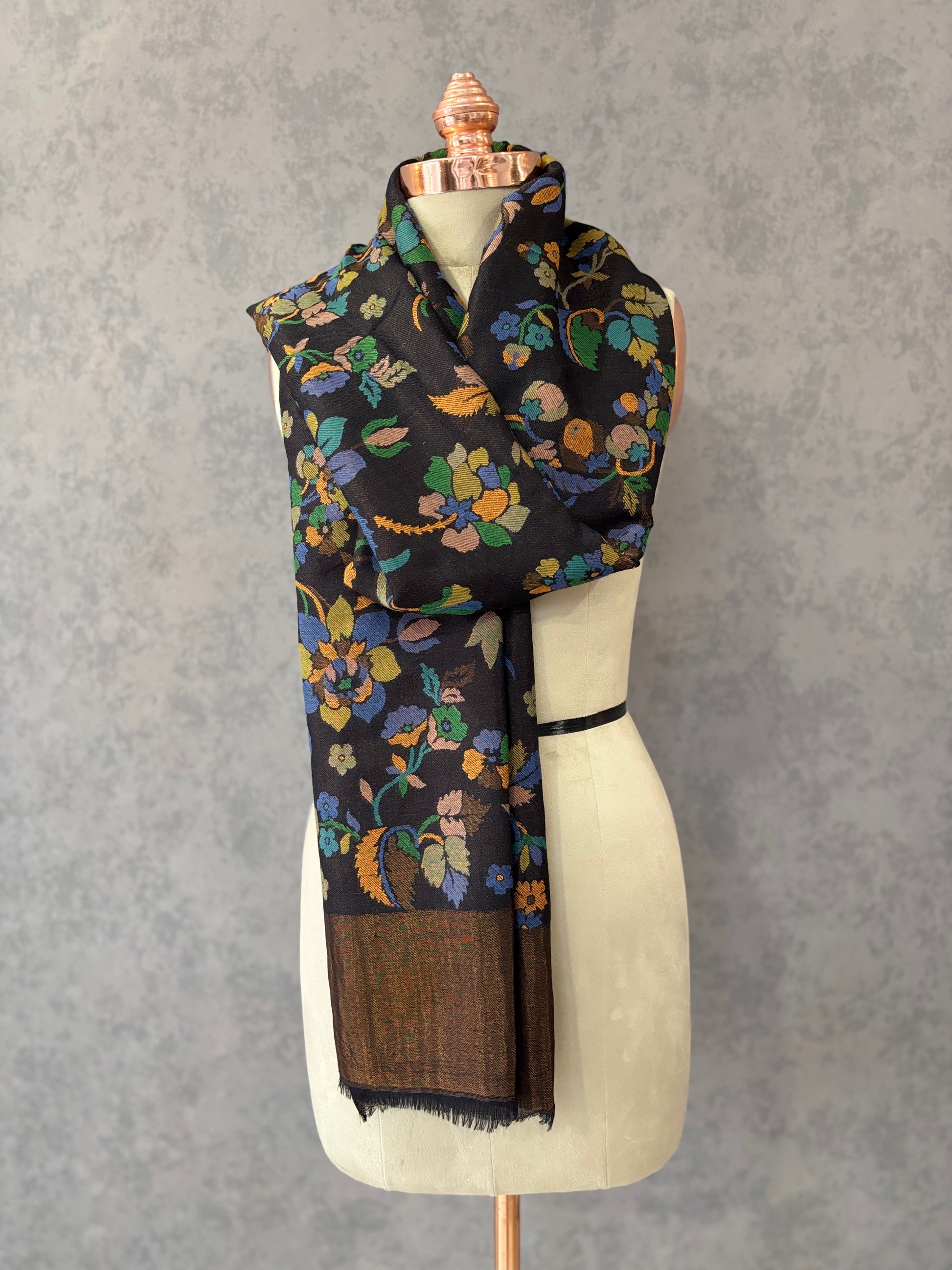 Black fine wool shawl with vibrant multicolor floral weave, draped on a mannequin